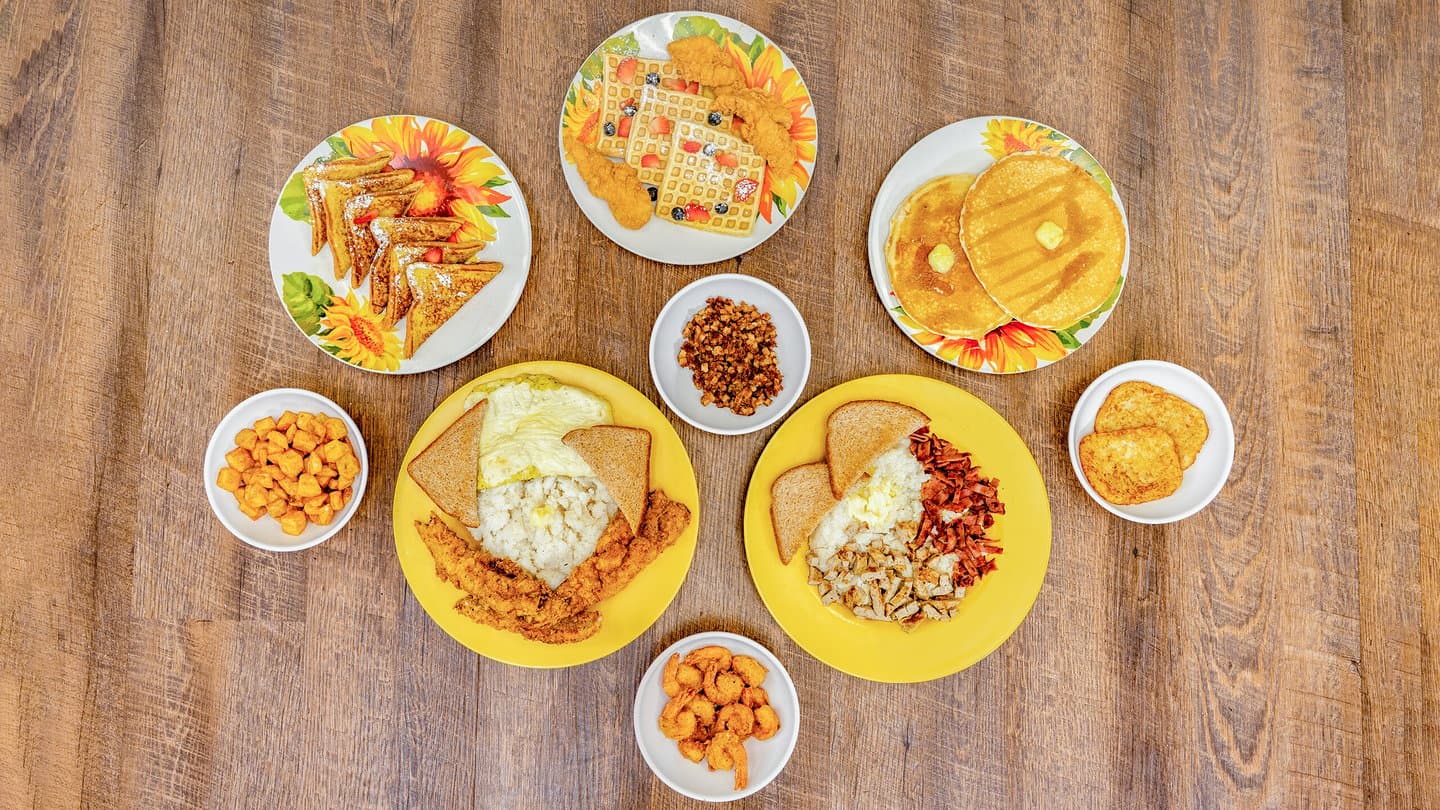 Capo's Breakfast Spot feast featuring Fish and Grits, Chicken and Waffles, and French Toast.